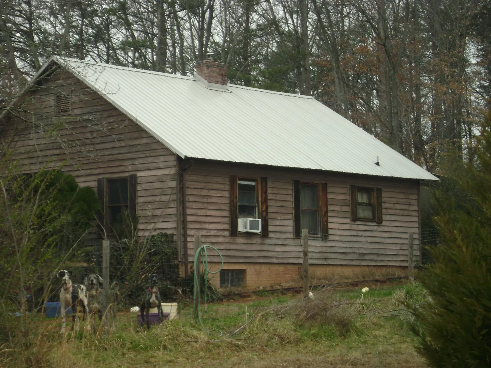 White metal roof on an old wood sided farmhouse, from a Metal Roof Installation job in Mitchell
